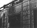 Closeup view of bullet-riddled walls and twisted window frames of Hangar 11
