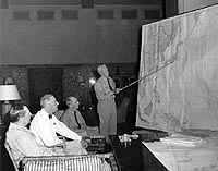 80-G-46221: Admiral Chester W. Nimitz (center) confers with General Douglas MacArthur, President Franklin D. Roosevelt and Admiral William D. Leahy concerning future moves in the war against Japan, circa July-August 1944.