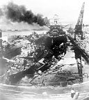 DAMAGED WARSHIPS. The U.S. destroyers Dowries, left, and Cassin, right,
and the battleship Pennsylvania, in background, shortly after the attack on Pearl
Harbor. Of the eight battleships hit, the Arizona was a total loss; the Oklahoma
was never repaired; the California, Nevada, West Virginia, Pennsylvania,
Maryland, and Tennessee were repaired and returned to service. The slight depth
of Pearl Harbor made possible the raising and refitting of these ships.