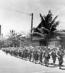 SOLDIERS LEAVING PIER to board trucks for Schofield Barracks, Honolulu. As
a result of the disaster at Pearl Harbor, the Hawaiian command was reorganized.
There was little enemy activity in the Central Pacific after the 7 December attack.
The Japanese had seized Wake and Guam and were concentrating on their southern
campaigns. As the build-up of men and equipment progressed, reinforcements
began to pour into Hawaii for training and shipment to Pacific stations.