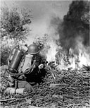 U.S. SOLDIER FIRING A FLAME THROWER at a Japanese position
