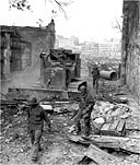 INFANTRYMEN PICK THEIR WAY ALONG A STREET of Intramuros as a bulldozer clears away the rubble