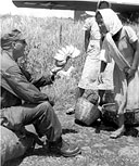 AN ENLISTED MAN of an airborne division buying bananas from native Filipinos