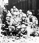 JAPANESE TROOPS posed in the streets of Shanghai. The Japanese had been
fighting in China since the early 1930's. During late 1941 and early 1942 Hong
Kong and Singapore fell to the enemy along with Malaya, North Borneo, and
Thailand. Control over the latter gave Japan rich supplies of rubber, oil, and
minerals--resources badly needed by the Japanese to carry on the offensive
against the Allies.