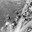 SURVIVORS OF THE USS LEXINGTON after the Battle of the Coral Sea. The
Lexington was so badly damaged that she had to be sunk by torpedoes from U.S.
destroyers. Both the U.S. and Japanese Navies inflicted damage on surface ships
and both lost aircraft in the battle. The opposing forces withdrew at about the
same time and the action can be considered a draw. Following this battle the
enemy no longer tried to send troops to Port Moresby by sea, an advantage to the
Allies who began to develop the area of northeastern Australia and New Guinea.
Instead, the Japanese sent troops overland to drive on Port Moresby and by 28
July 1942 had captured Kokoda, key to the mountain pass through the Owen
Stanley Range.