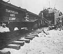 FROM THE GAPING BOW OF THE <i>LST-21</i> RESTING ON THE FRENCH BEACH FREIGHT CARS OF THE ARMY TRANSPORTATION CORPS ROLL INLAND FOR THE TRIP TO THE WESTERN FRONT WITH SUPPLIES FOR ALLIED ARMIES