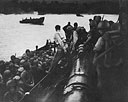 A PT disembarks troops into a landing craft at Nassau Bay, July 6, 1943