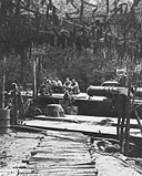 A boat crew relaxes on deck of a PT under camouflage net in the Morobe River