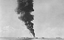 An LCI, hit by an enemy suicide plane in Leyte Gulf, burns as PT's move in to pick up survivors