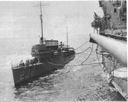 Saratoga (CV-3) is shown fueling destroyers at sea in the early 1930s