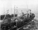 By the end of the war, oilers were routinely transferring stores and munitions while conducting fueling at sea. Extra belly tanks for aircraft and containers of ammunition were often stowed on the open spar deck. The tall ventilator/kingpost combination and the round cargo tank hatches identify this as a Chiwawa-class oiler. (National Archives) 