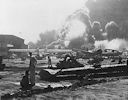 Image: 80-G-19948 Wreckage at Naval Air Station, Ford Island, with ships burning in background, 7 December 1941.