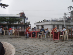 rooftop teahouse with monks