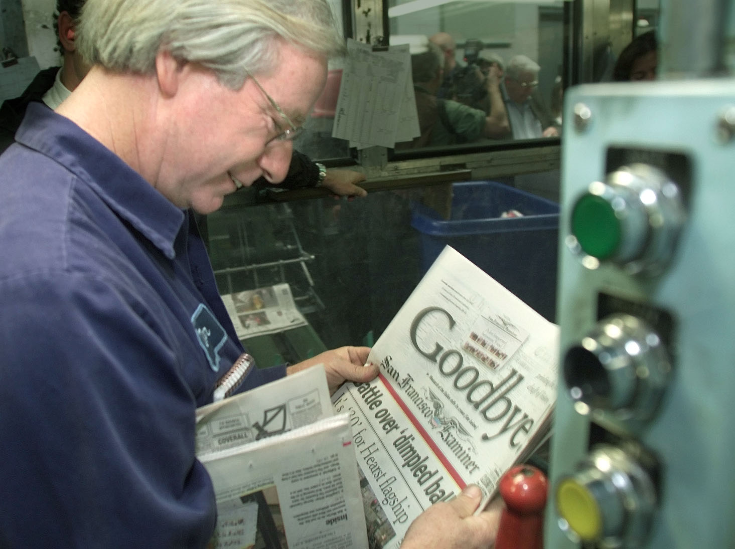 A man looks at the headline Goodbye as the San Francisco Examiner comes of the press before the merger