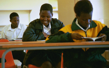 A learner at DD Mabuza Comprehensive High School smiles with delight as she reads a new African book purchased through the WLP book certificate program.