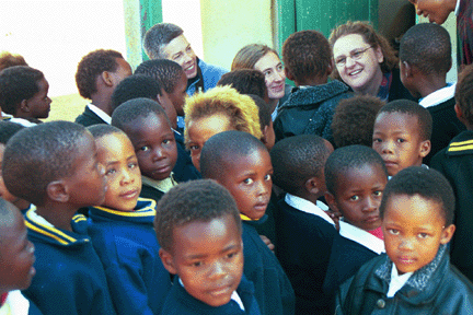 WLP volunteers Chloe Keefer, Lynn Hallquist and Maggie Hite break the ice with kindergartners at Monnophang Primary School by having them write their names.