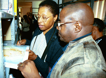 WLP volunteer Margaret Traylor and principal Aaron Mbatha examine a new African book at READ Educational Trust.