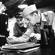 Photo # 80-G-308561: Commander John S. Thach (foreground) working with Vice Admiral John S. McCain on board USS Hancock, circa November 1944-January 1945