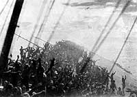 Photo # NH 73070: Crewmembers give a final 'Banzai' cheer as the Japanese Naval Ensign is lowered on the sinking aircraft carrier Zuikaku, 25 October 1944.