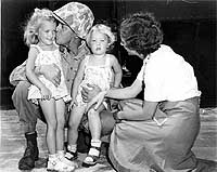 Photo # NH 97026: A Marine bids farewell to his wife and two daughters as elements of the Second Marine Division leave for the West Coast en route to Korea, circa August 1950
