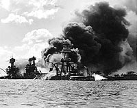 Photo # NH 97378: View looking up 'Battleship Row' on 7 December 1941, just after the Japanese attack on Pearl Harbor.  USS Arizona is burning in the center.