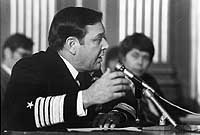 Photo # NH 103811: Admiral James L. Holloway, III, speaking before microphones