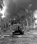 INFANTRYMEN, supported by a medium tank M4A1, move forward to wipe out the remaining enemy