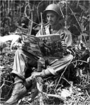 INFANTRYMAN READING AN ISSUE OF YANK MAGAZINE