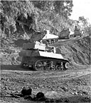 TANKS driven by American-trained Chinese soldiers making a sharp horseshoe turn on the road to Bhamo