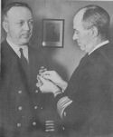 VICE ADMIRAL R. R. WAESCHE, COMMANDANT OF THE U.S. COAST GUARD PINS THE LEGION OF MERIT ON CAPTAIN CHARLES W. HARWOOD