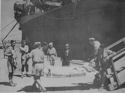 IN A NORTH AFRICAN PORT AMERICANS WOUNDED IN THE FIRST DAYS OF THE INVASION OF SICILY ARE UNLOADED FROM A COAST GUARD-MANNED TRANSPORT