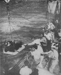 WOUNDED SOLDIERS ARE HOISTED ABOARD A COAST GUARD TRANSPORT OFF A SICILIAN BEACH
