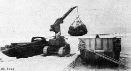 Figure 5.--Use of mobile hydraulic crane in unloading small amphibious craft. Note use of lines to stabilize crane in handling heavy loads. (Marines in the Marianas.)